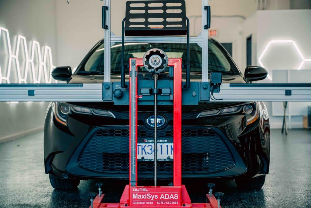 ADAS calibration frame positioned in front of a Toyota for post-windshield alignment.